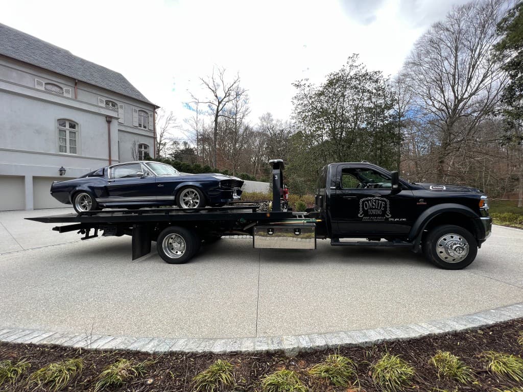 On-Site Towing flatbed truck transporting a vehicle